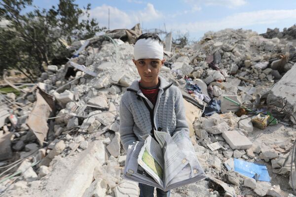 地震で倒壊した自宅の瓦礫の上に立つ少年（シリア・ジンディレス、11日） - Sputnik 日本