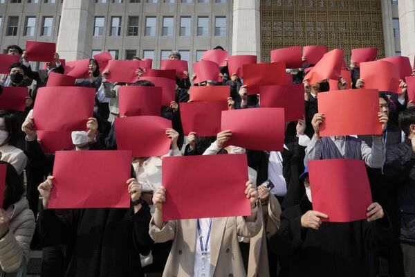 国会議事堂前で行われた徴用工問題への賠償金をめぐる韓国政府の方針に反対する集会で、赤色の紙を掲げる市民団体（韓国・ソウル、7日） - Sputnik 日本