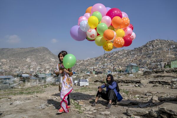 イラン暦の元日「ノウルーズ」を祝い、風船売りから風船を買う少女（アフガニスタン・カブール） - Sputnik 日本