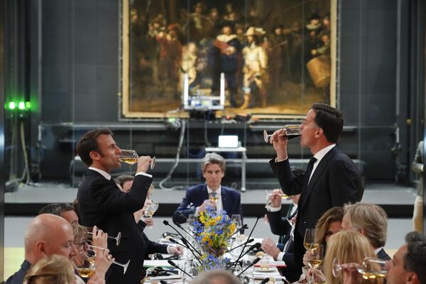 アムステルダム国立美術館に展示されているレンブラントの『夜警』の前で乾杯するマクロン仏大統領とルッテ・オランダ首相（オランダ・アムステルダム、12日） - Sputnik 日本