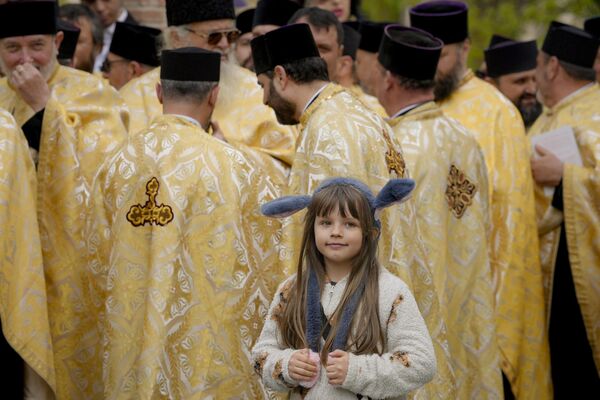 キリストのエルサレム入城を記念する「花の主日」を前に、巡礼を始めるルーマニア正教会司祭の隣に立つ少女（ルーマニア・ブカレスト、8日） - Sputnik 日本
