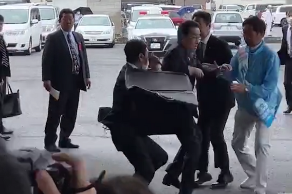Телохранитель закрывает премьер-министра Японии Фумио Кисида во время броска взрывоопасного предмета перед его выступлением в Вакаяме, 15 апреля 2023. Скриншот видео - Sputnik 日本