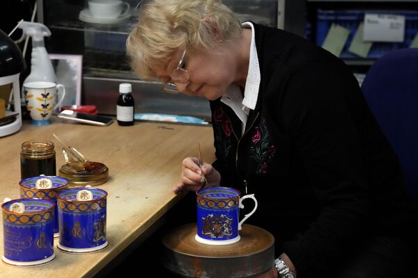 窯元で戴冠式記念のマグカップに仕上げ塗りをする作業員（ストーク・オン・トレント、13日） - Sputnik 日本