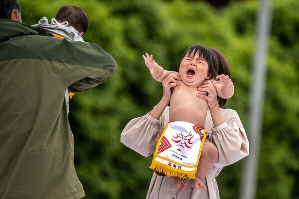 浅草寺で4年ぶりに再開された「子泣き相撲」で、親に抱きかかえられる子どもたち（日本・東京台東区、22日） - Sputnik 日本