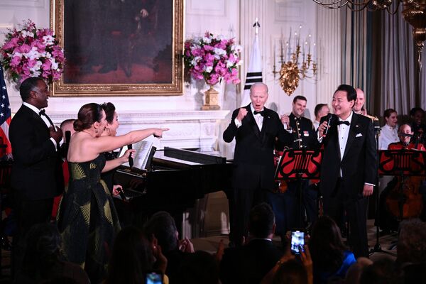 ホワイトハウスで行われた晩餐会で、米歌手のノーム・ルイスさん（左）、ジェシカ・ボスクさん（左2）、レア・サロンガさんとともにステージ上で話すジョー・バイデン米大統領と尹錫悦大統領・韓国大統領（米ワシントン、26日） - Sputnik 日本