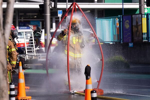 火災が発生した宿泊施設の周辺で除染シャワーを浴びる消防隊員（ニュージーランド、ウェリントン、16日） - Sputnik 日本