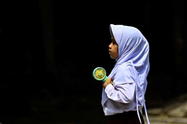 携帯扇風機で涼をとる小学生（インドネシア・バンダ・アチェ、15日） - Sputnik 日本
