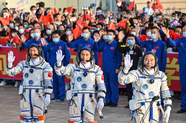 酒泉衛星発射センターで行われた「神舟16号」搭乗前の出発式で手を振る北京航空航天大学の桂海潮教授（左）、朱楊柱（中央）飛行士、景海鵬飛行士（右）（中国・甘粛省、30日） - Sputnik 日本