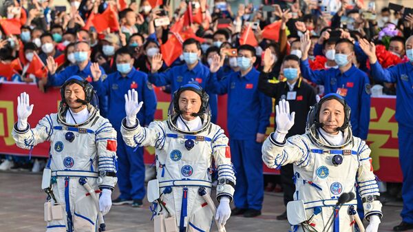 酒泉衛星発射センターで行われた「神舟16号」搭乗前の見送り式で手を振る北京航空航天大学の桂海潮教授（左）、朱楊柱（中央）飛行士、景海鵬飛行士（右）（中国・甘粛省、30日） - Sputnik 日本