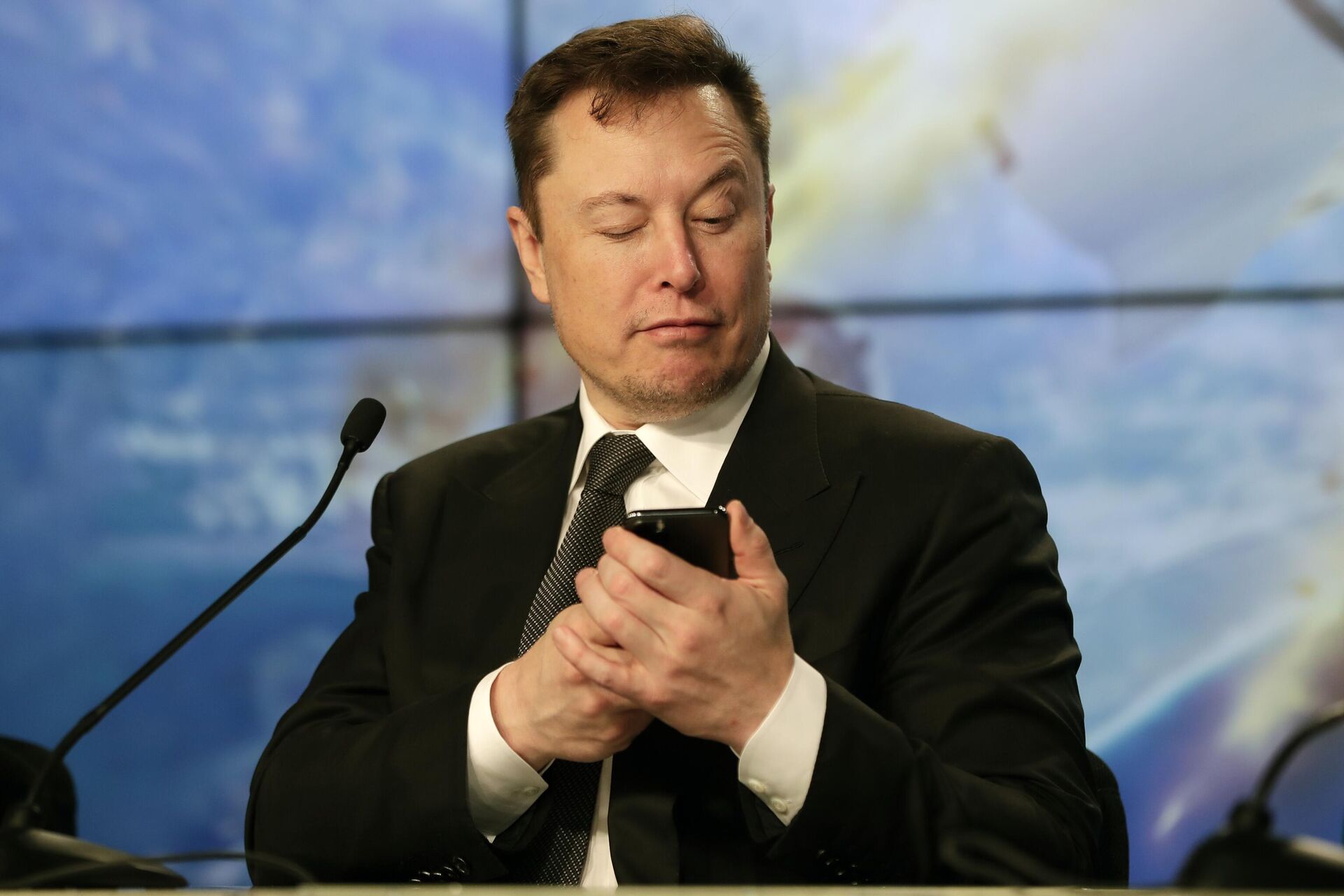 Основатель SpaceX Илон Маск шутит с журналистами, делая вид, что ищет ответ на вопрос по мобильному телефону во время пресс-конференции - Sputnik 日本, 1920, 21.12.2023