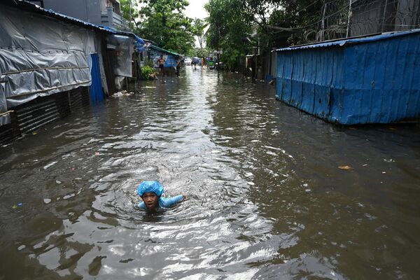 大雨の後、冠水した通りで泳ぐ少年（ミャンマー・ヤンゴン、28日） - Sputnik 日本