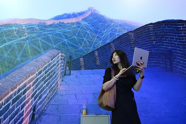 世界人工知能会議2023で、万里の長城が描かれたポスターの前に立つ女性（上海、6日） - Sputnik 日本