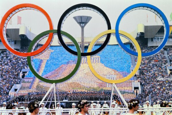 レーニン・スタジアム（現：ルジニキ・スタジアム）で行われた開会式で、人文字で作られたパルテノン神殿を背景に運ばれる五輪マーク（1980年7月19日撮影） - Sputnik 日本
