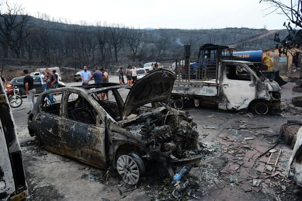 激しい森林火災によって燃えた車を見物する人たち（アルジェリア北部ブイラ） - Sputnik 日本