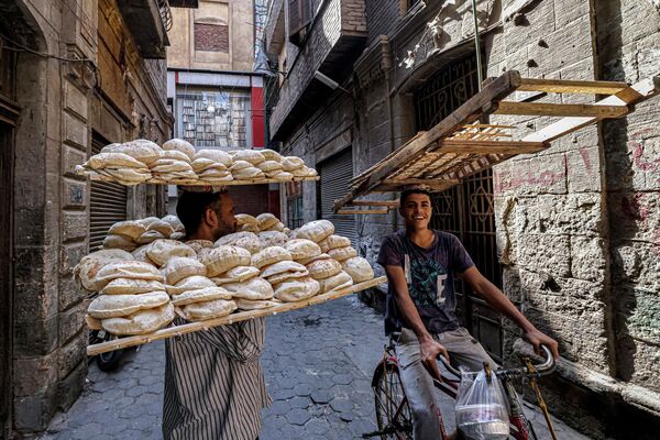 焼きたてのエジプトの伝統的なパンをのせたトレイを渡す準備をする行商人（エジプト・カイロ） - Sputnik 日本