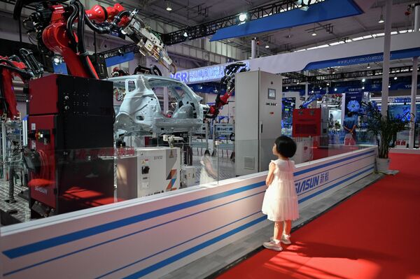 世界ロボット大会で、展示されているロボットアームを見つめる子ども（北京、16日） - Sputnik 日本