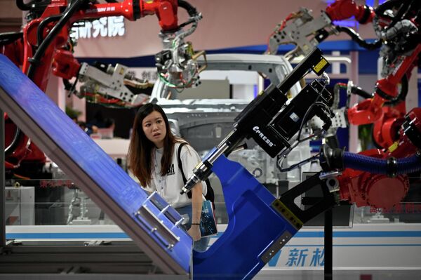 世界ロボット大会で、展示されているロボットアームを見つめる来場者（北京、16日） - Sputnik 日本