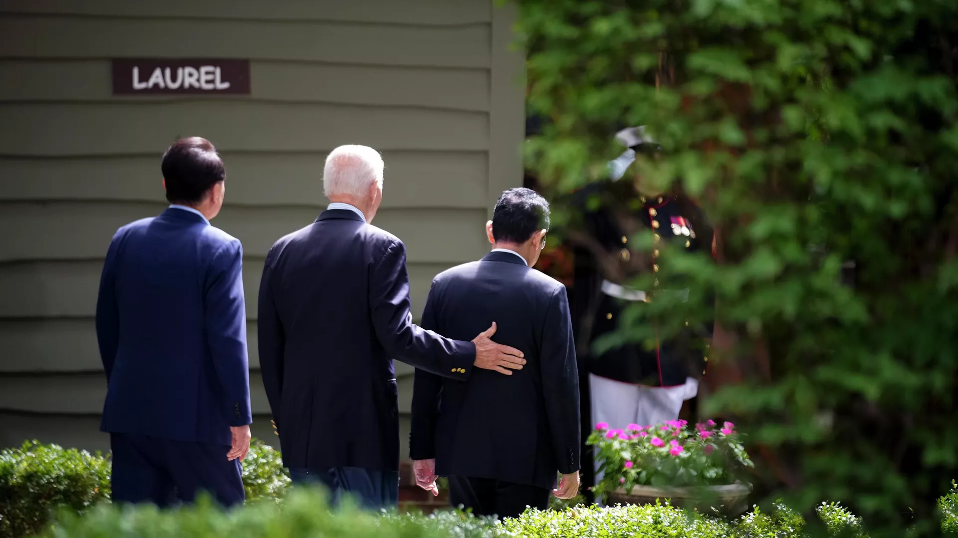 岸田首相（右）の背中を押すバイデン大統領（中央）