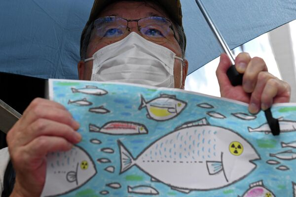 東京電力本部前で行われた処理水放出に反対する集会で、抗議の絵を掲げる男性（東京都千代田区、24日） - Sputnik 日本