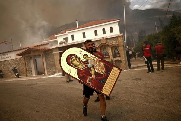 山火事が広がる中、燃える修道院からイコンを運ぶボランティア（ギリシャ・アハルネス、23日） - Sputnik 日本
