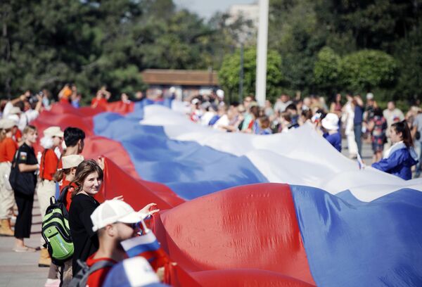 「国旗の日」を記念したイベントで、長さ100メートルのロシア国旗を広げる人々（露ドネツク人民共和国・マリウポリ、22日） - Sputnik 日本