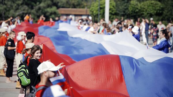 「国旗の日」を記念したイベントで、長さ100メートルのロシア国旗を広げる人々（露ドネツク人民共和国・マリウポリ、22日） - Sputnik 日本