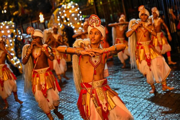 「エサラ・ペラヘラ祭」を祝う行列で、仏教寺院「仏歯寺」の前で踊る伝統舞踊家（スリランカ・キャンディー、29日） - Sputnik 日本