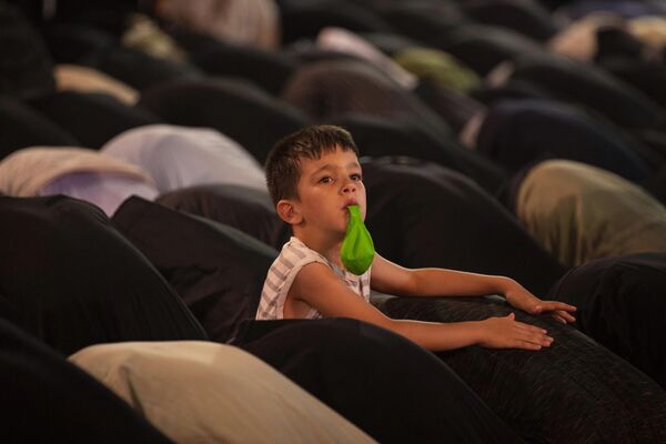 イスラム教・シーア派の祭り「アルバイーン祭」前夜、聖地カルバラーで祈りが捧げられる中、風船を膨らませる少年 （イラク・カルバラー、5日） - Sputnik 日本