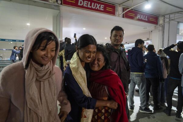 イスラエルから退避便でネパールのトリブバン国際空港でに到着した娘を出迎える女性（13日） - Sputnik 日本