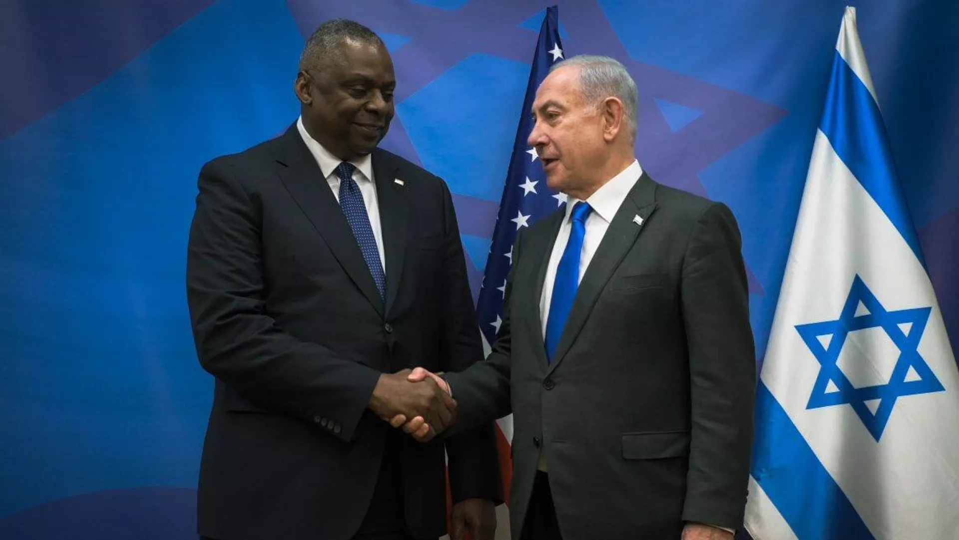 握手する米国のオースティン国防長官とイスラエルのネタニヤフ首相