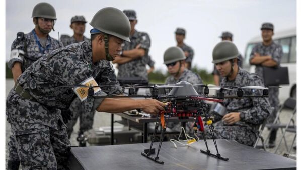 Военнослужащий Сил самообороны ВВС устанавливает беспилотник во время двусторонних учений с боевой стрельбой на полигоне Драугхон, недалеко от авиабазы ​​Мисава, в префектуре Аомори, Япония - Sputnik 日本