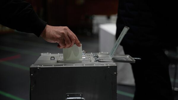Избиратель голосует на избирательном участке в Токио в воскресенье, 8 февраля 2026 года, на выборах в нижнюю палату парламента - Sputnik 日本