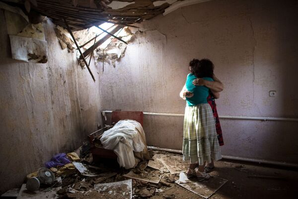スラヴャンスク郊外、ウクライナ軍の夜間砲撃で壊れた家のなかにいる女性たち - Sputnik 日本