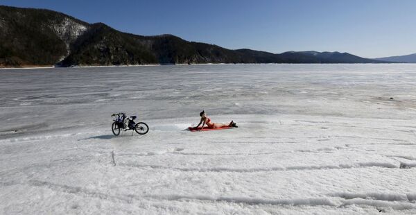 気温マイナス１３度の中、シベリアのエニセイ川の氷の上で日焼けする女性。 - Sputnik 日本