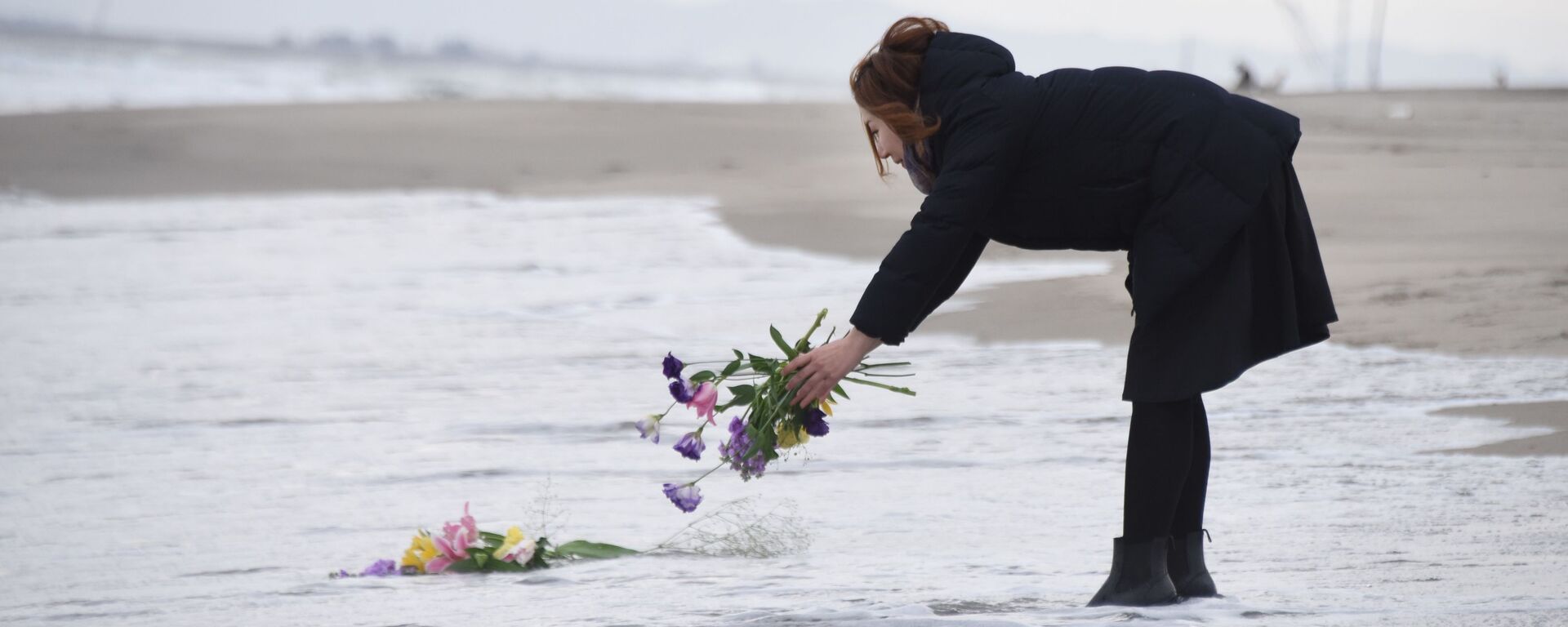津波の犠牲者の追悼のため水に花を投げ入れる女性 - Sputnik 日本, 1920, 05.11.2021