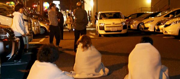 People wrapped in blankets sit on the road as they are evacuated from a hotel after an earthquake in Kumamoto, southern Japan, in this photo taken by Kyodo April 14, 2016 - Sputnik 日本