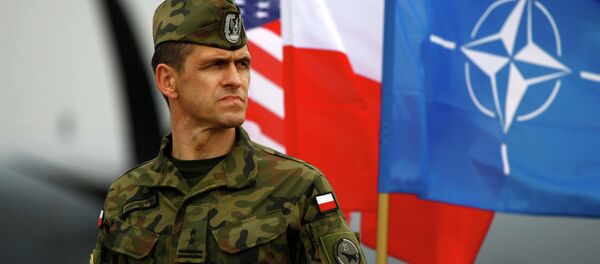 A Polish soldier stands near US and Poland's national flags and a NATO flag in Swidwin, northern west Poland, April 23, 2014 - Sputnik 日本