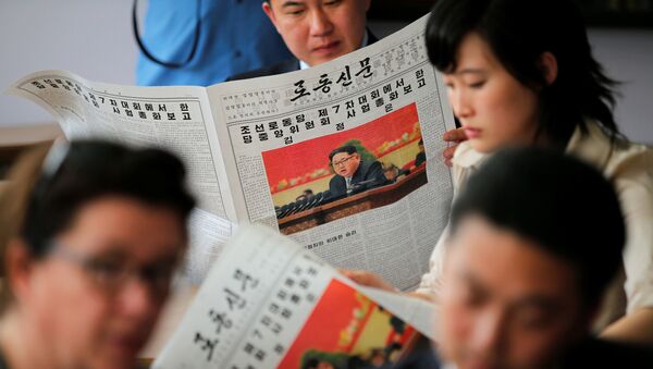 Люди с газетами с изображением лидера КНДР Ким Чен Ына - Sputnik 日本