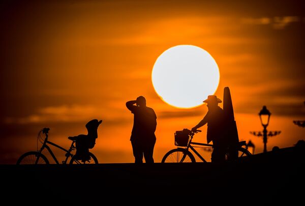 ソチの五輪公園近くの海岸線で夕焼けをバックに走るサイクリスト - Sputnik 日本