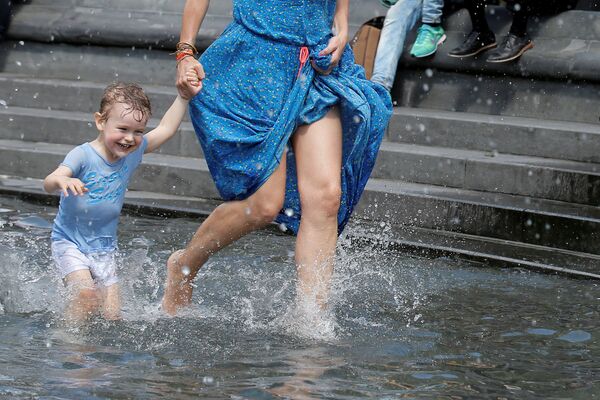 子供を抱き噴水で水浴びする女性　ニューヨーク・ワシントン・スクエア。 - Sputnik 日本