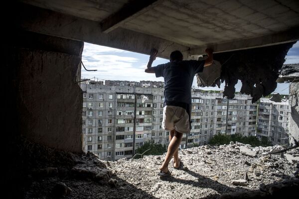 砲撃で破壊された住居を調べる男性。２０１４年７月１４日、ルガンスク、ミールヌィ（平和）地区。 - Sputnik 日本