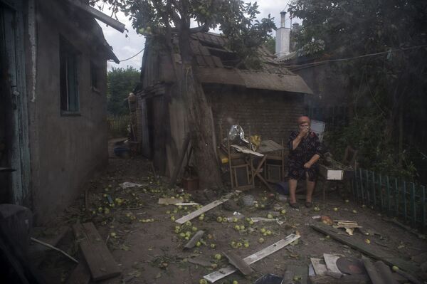 ルガンスク、ウクライナ治安維持部隊の砲撃で破壊された家の前にたたずむ女性。 - Sputnik 日本
