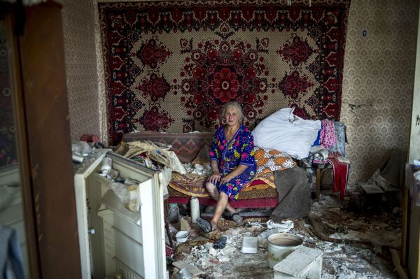 ウクライナ軍の空爆で破壊された家の中で呆然とする地元女性。ルガンスカヤ村で。 - Sputnik 日本