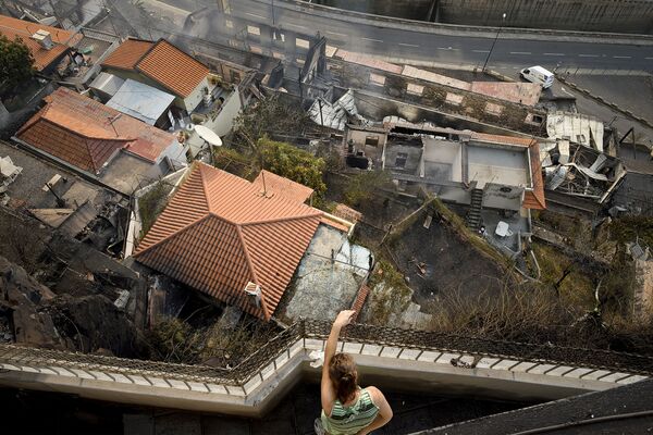 バルコニーから火の出た家を見る女性　マデイラ島の町フンシャルで。 - Sputnik 日本