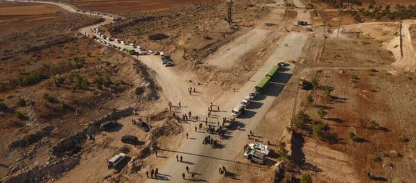 Сотрудники правоохранительных органов у автобусов и машин скорой помощи в районе гуманитарного коридора у трассы Кастелло на севере Алеппо в Сирии Сотрудники правоохранительных органов у автобусов и машин скорой помощи в районе гуманитарного коридора у трассы Кастелло на севере Алеппо в Сирии - Sputnik 日本