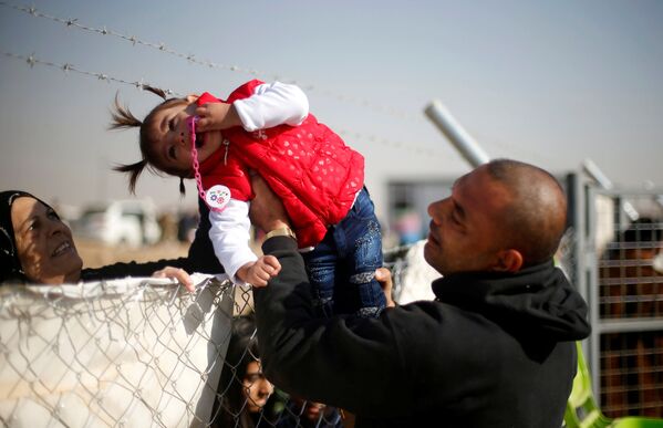 イラクの難民キャンプ柵越しに娘を老婆に手渡すダーイシュ（IS）支配地域からの逃亡男性 - Sputnik 日本