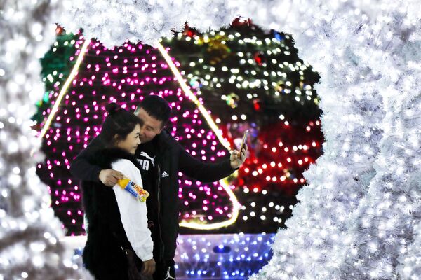 北京で新年の飾りの近くでセルフィーする恋人たち。 - Sputnik 日本