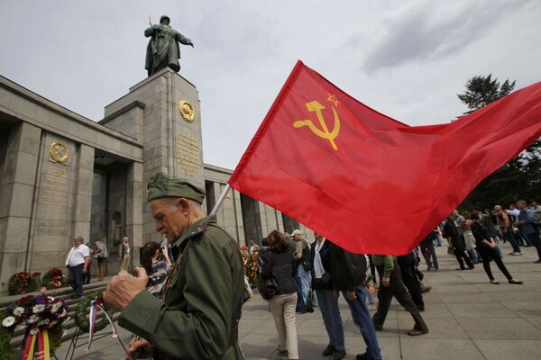 ベルリン、ソ連軍の軍服を身につけ、ソ連の国旗を手に歩く男性 - Sputnik 日本