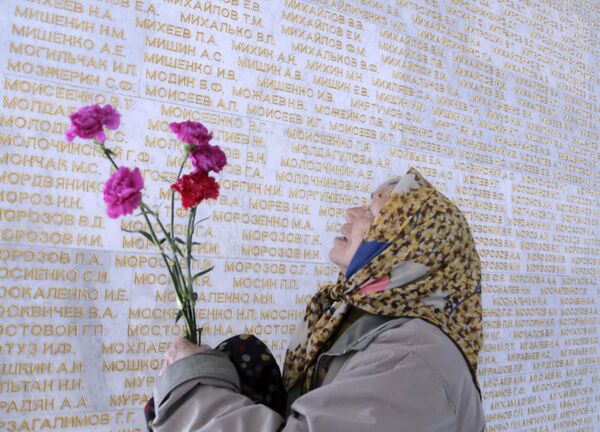 キエフでの戦勝記念日、ソ連軍の戦死兵の名が刻まれた壁をなぞり、自分の兄を探す年老いた女性。 - Sputnik 日本