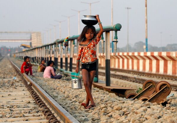 インドで頭の上に容器をのせて運ぶ少女。 - Sputnik 日本